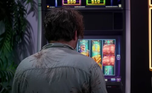 Мужчина стоит перед игровым автоматом